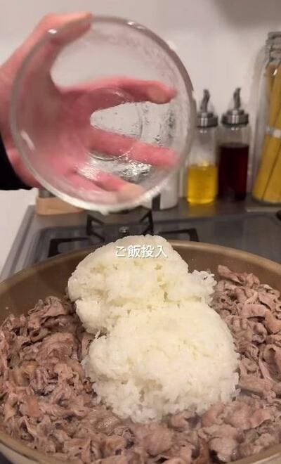 炒めた牛こま切れ肉の真ん中にのせられたご飯