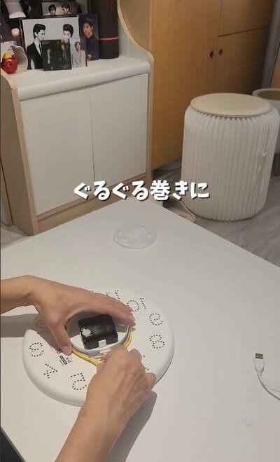 時計の裏側にテープライトをぐるぐる巻きにしていく様子