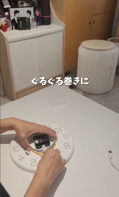 時計の裏側にテープライトをぐるぐる巻きにしていく様子