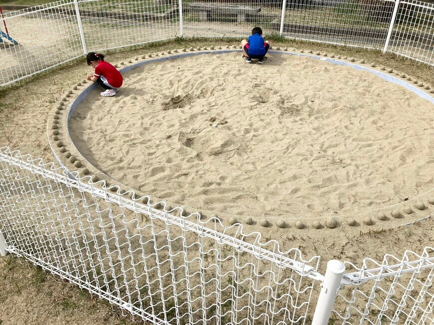 砂場に芸術作品を並べる子供達