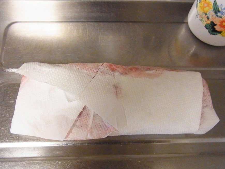 新しいキッチンペーパーで豚肉をくるむ。