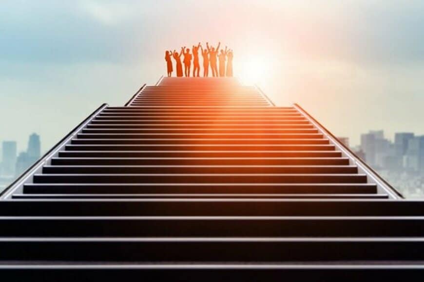 階段の上で手を挙げる人々