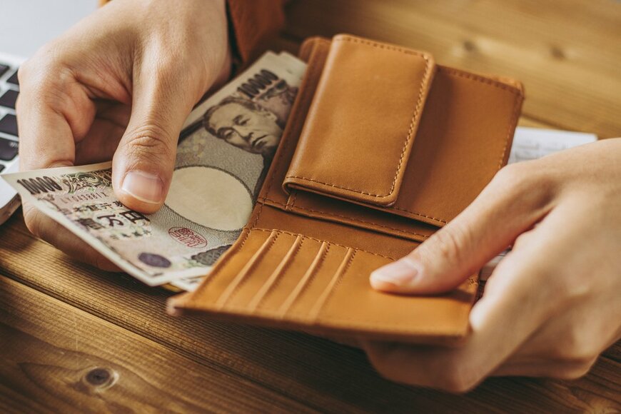 財布からお金を出している写真