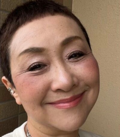 オフホワイトのワントーンコーデをまとめた64歳マダム。ブルーとイエローの差し色とシルバーアクセサリーの重ね付けを活かした着こなし