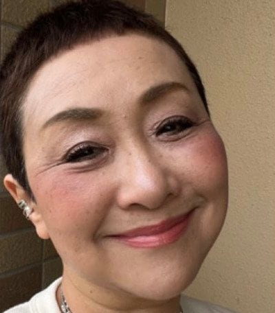 オフホワイトのワントーンコーデをまとめた64歳マダム。ブルーとイエローの差し色とシルバーアクセサリーの重ね付けを活かした着こなし