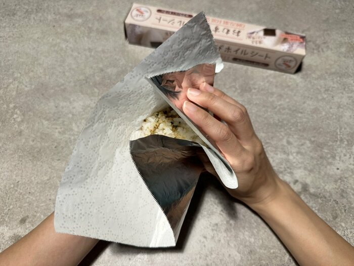 ホイルシートでごはんを包みながら、三角おにぎりになるようににぎります