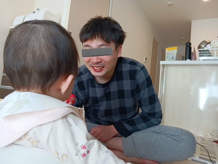 口紅を塗って赤ちゃんに笑いかける旦那さん