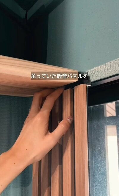 余っていた吸音パネルを窓枠の側面にあてがう様子