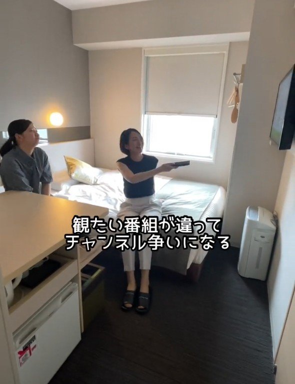ホテルでテレビを見る2人