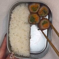 彩り鮮やかな断面で食欲をそそる「肉巻き弁当」がきっちり綺麗に詰まって見栄え抜群で美味しそう！スプーンでブロッコリーを押さえながらおかずの隙間を埋めていくお弁当の詰め方が参考になる