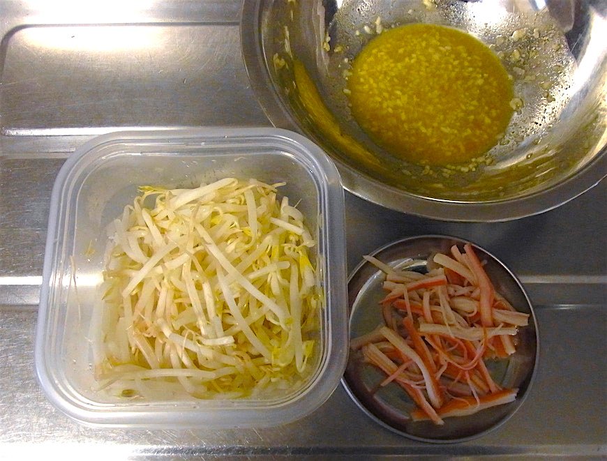 分量の塩麹と酢とカレー粉をよく混ぜ、もやしとカニカマを和える