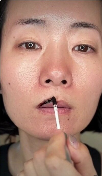 リップティントを唇の枠にのせるシーン