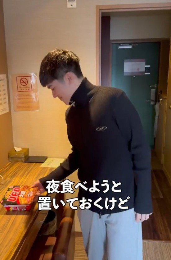 カップ麺を置く男性