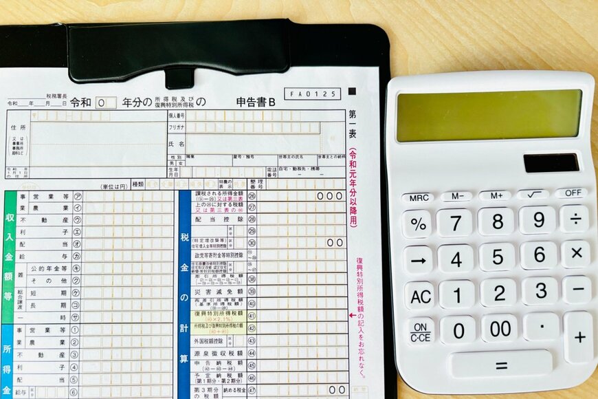 確定申告書と計算機が並んでいる