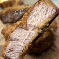 肩ロース1枚をドーンと乗せた「カツ丼」の夫弁当アイデア。油で揚げずオーブンで焼く調理法と、お花型の大根を添えた彩り豊かな見栄えが参考になる実用的なお弁当術