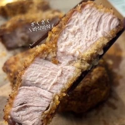 肩ロース1枚をドーンと乗せた「カツ丼」の夫弁当アイデア。油で揚げずオーブンで焼く調理法と、お花型の大根を添えた彩り豊かな見栄えが参考になる実用的なお弁当術