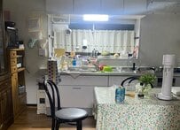 キッチンの床に転がる猫が注目の的　見切れる構図に「まんぞくさんがおる」「パラサイトみたい」