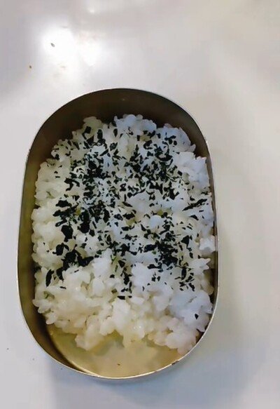 小さめの弁当箱にご飯を詰める