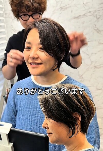 仕上がりを見て笑顔を見せる女性
