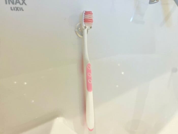 歯ブラシホルダーに歯ブラシを引っ掛けているところ