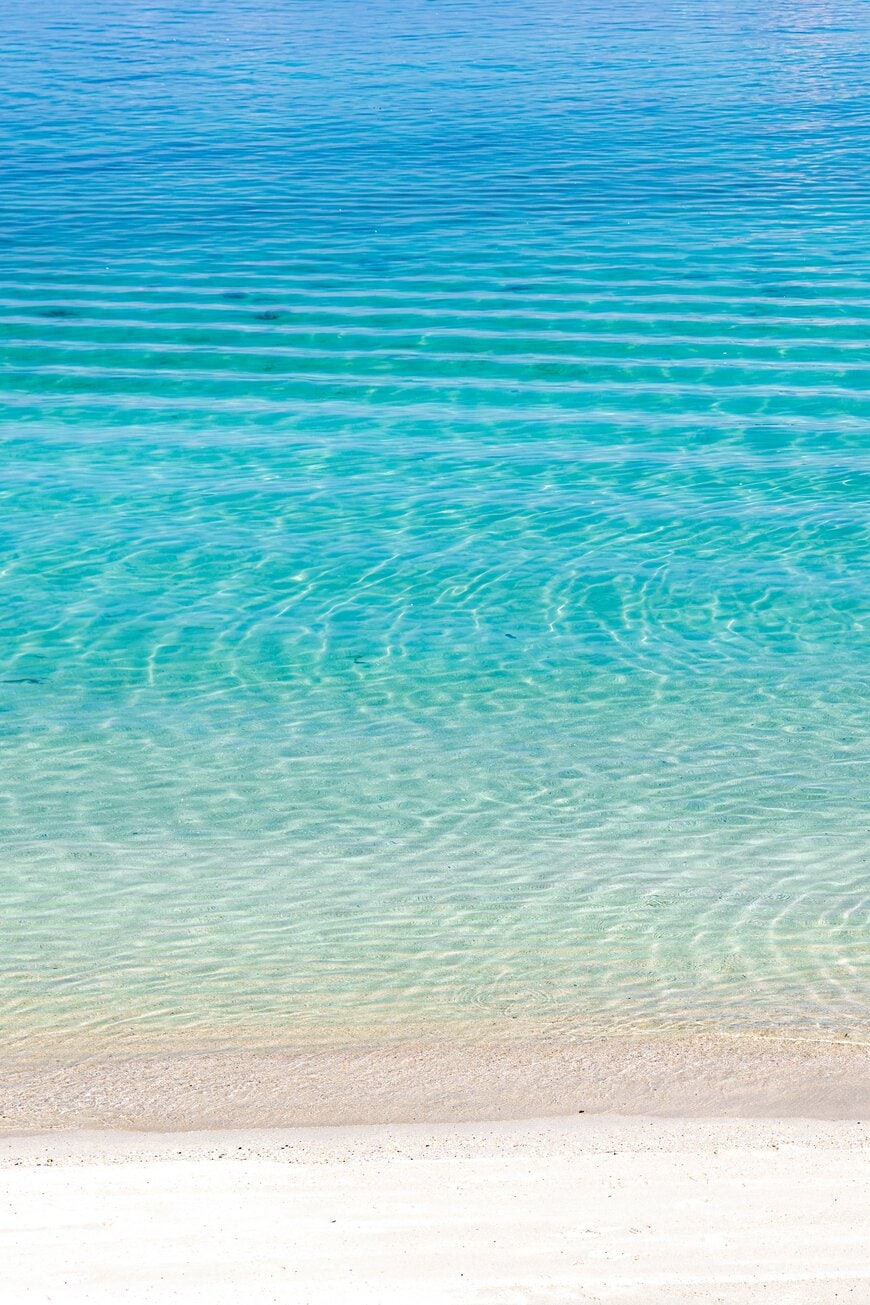 白い砂浜から海へと広がる青のグラデーション
