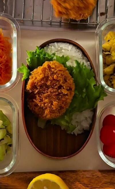 葉野菜の上にのせられた1枚目のヒレカツ