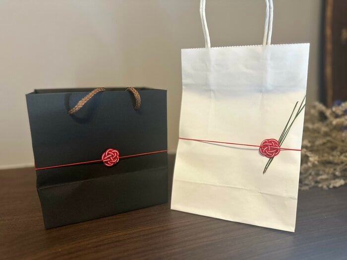 黒い紙袋にかけると、赤い水引がより際立つ印象に