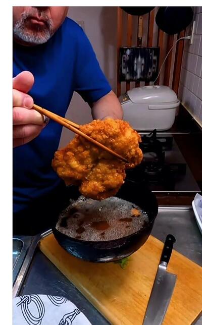 鶏もも肉にパン粉をまとわせ、油でこんがりと揚げているところ