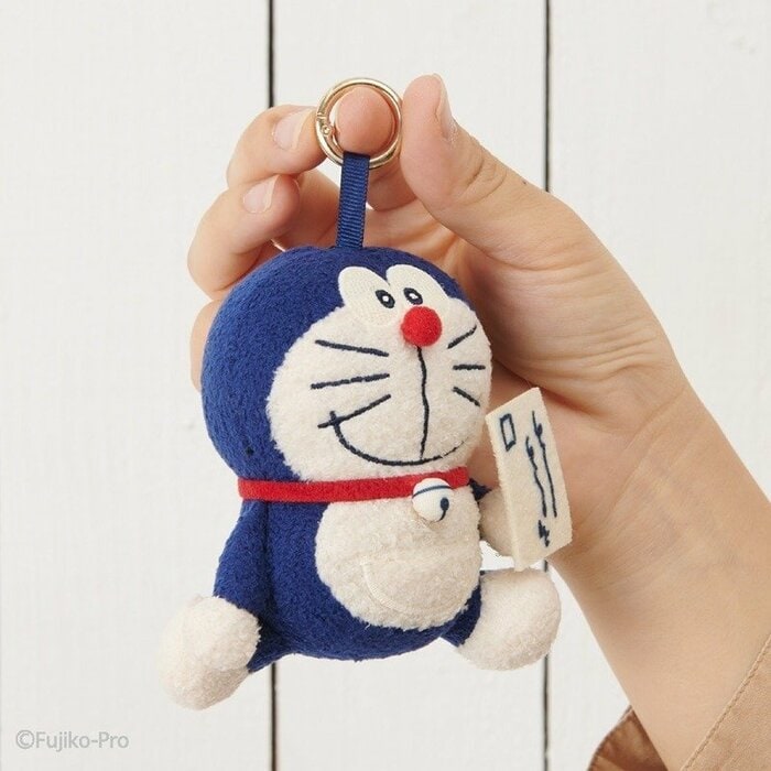 ドラえもんが小さなおてがみを手に持っています