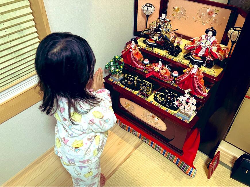 雛人形にお願いをする4歳児