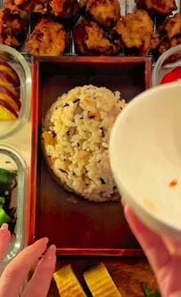 【炊き込みご飯と唐揚げ弁当】きのことひじきのご飯の横に、7品のおかずが一列に並ぶ秋の一箱が美味しそう