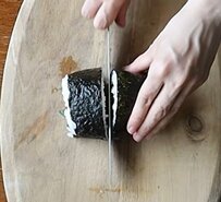 【お弁当アイデア】タッパーに詰める4人分の〈巻きおにぎり弁当〉。具材による3色のコントラストを活かし、彩り豊かな断面の美しさを引き出した実用的なお弁当テク