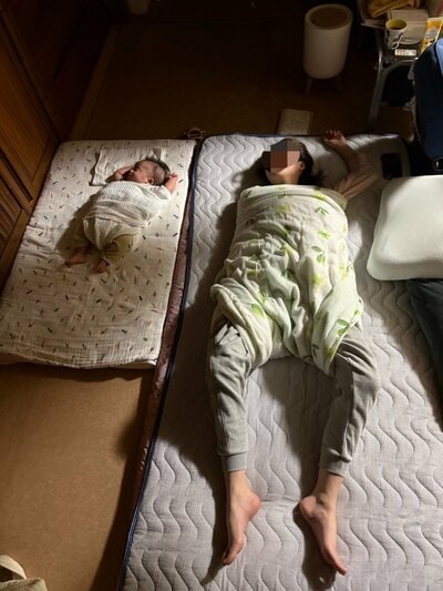 おくるみに巻かれて眠る親子