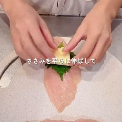 大きな「ささみの大葉チーズ焼き」がご飯の上にドン！丸いお弁当箱におかずもごはんもたっぷりギュッと詰まった旦那さんへのお弁当がおいしそう