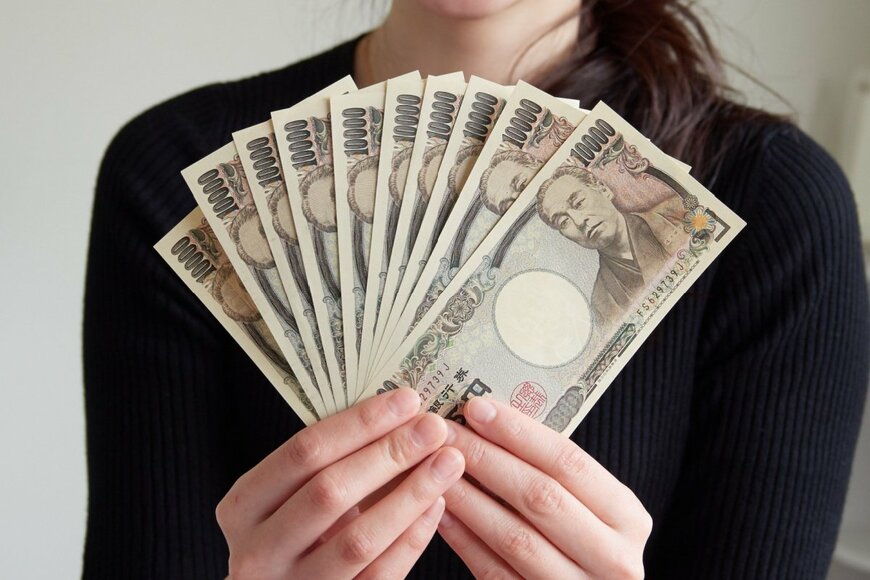 お金を持つ女性の写真