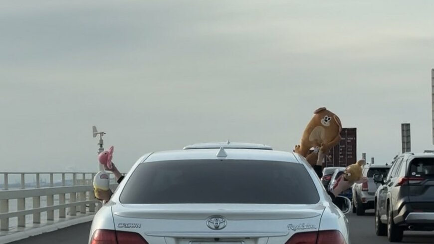 自動車の窓から顔を出すぬいぐるみ