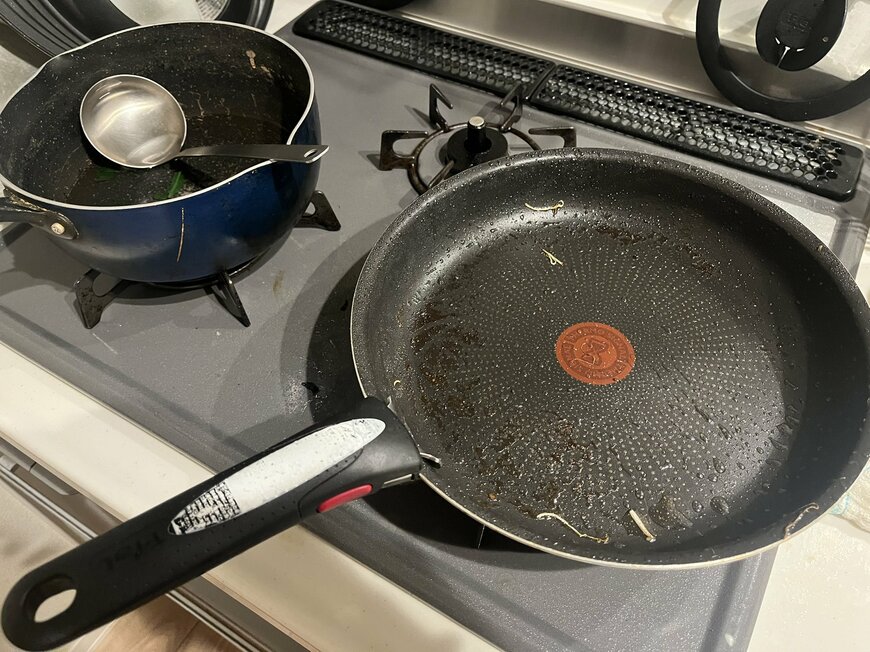 コンロに残された調理後のフライパンと鍋