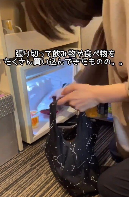 冷蔵庫にたくさんの飲み物や食べ物を入れようとする様子