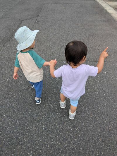 手をつないで散歩する双子