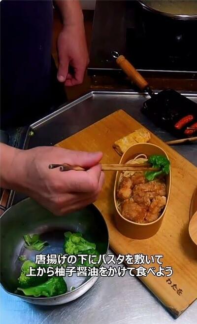 パスタの上に唐揚げが詰められていくお弁当箱