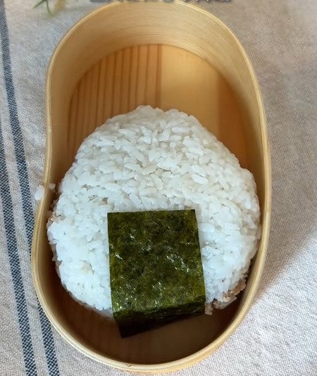 里芋や卵焼きなどのおかずをおにぎりの形に揃えた、遊び心あふれるお弁当アイデア。全部がおにぎりのように見える可愛らしい見た目のユニークな盛り付け術