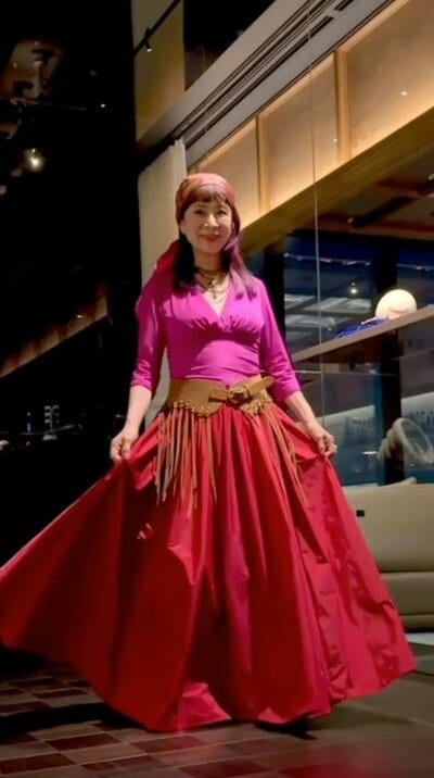 ふんわり広がる赤いロングスカートとフリンジ付きのベルト