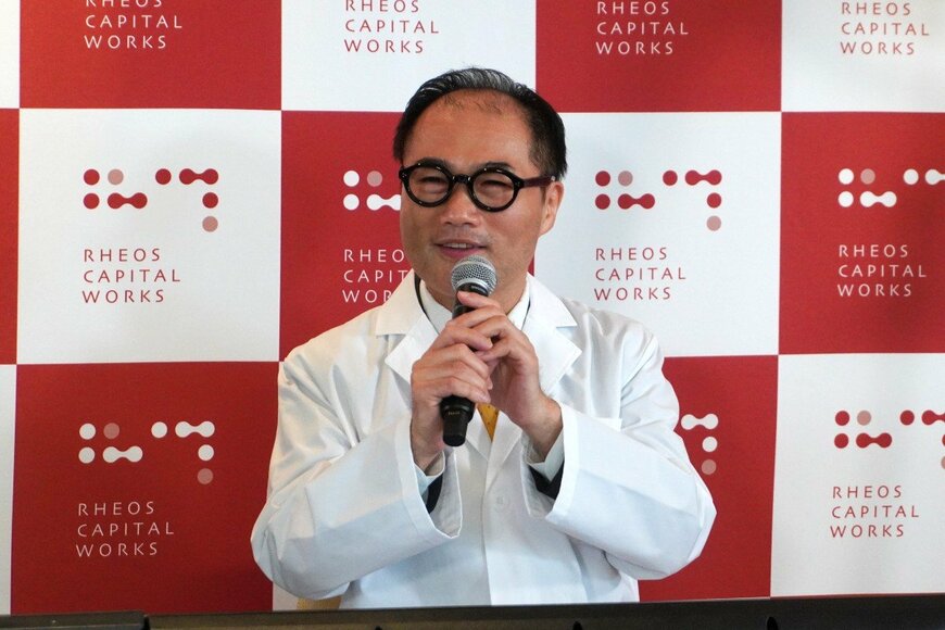 発表会で話す男性の写真