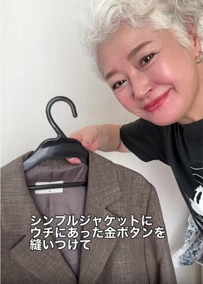 シンプルなジャケットと手持ちの金ボタン