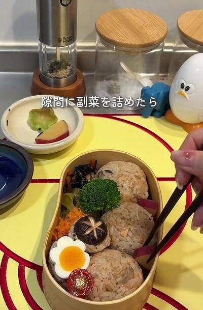 おにぎりのまわりに副菜が詰められたところ