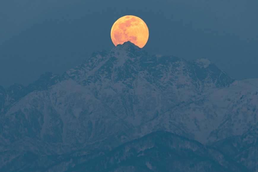 富山県・剱岳にのぼる「美しい満月」　険しい山に突き刺さる月が神々しい…