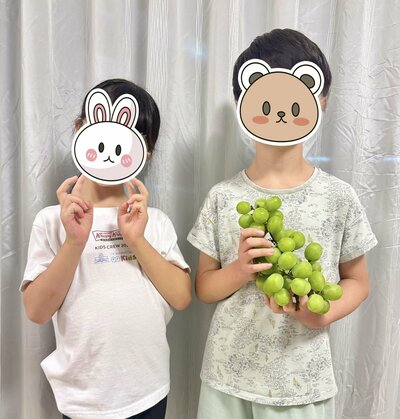 シャインマスカットを手に喜ぶ兄妹