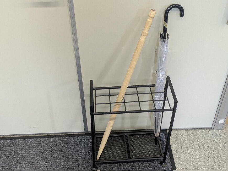 傘立てに挿さった傘と大きな爪楊枝