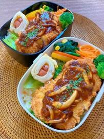 チキンカツ弁当をよく見ると…「こちらを見つめるつぶらな瞳」の正体は！？迫力ある”ソーセー人”が話題