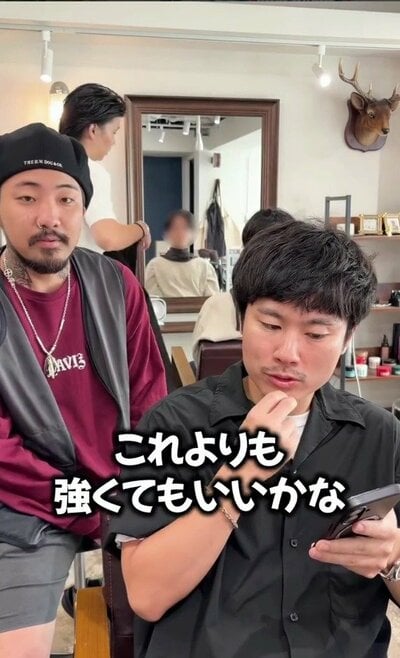 黒髪のショートで、スマホを見ながら美容師に相談する来店時の様子